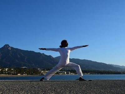 Silhouette of a person in a balancing yoga pose at sunrise.